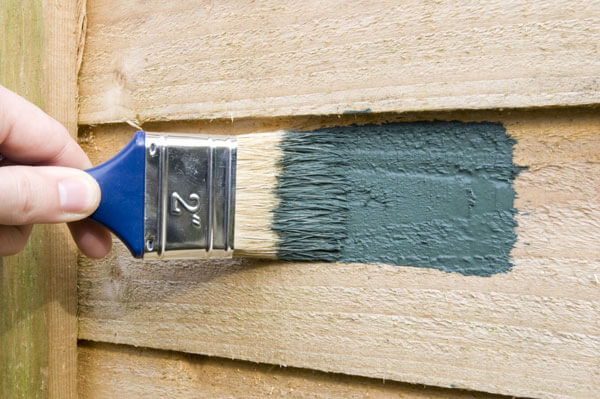 Applying a fence stain on a fence panel that has turned grey over time